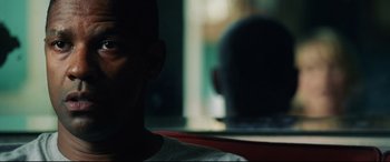 Movie still from “Man on Fire” (2004), directed by Tony Scott – A man sitting in front of a window with a blurry background; Close Up shot, Over the shoulder angle