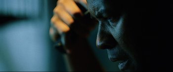 Movie still from “Man on Fire” (2004), directed by Tony Scott – A man's face while holding his hand to his ear; Extreme Close Up shot, Low angle