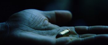 Movie still from “Man on Fire” (2004), directed by Tony Scott – A hand is holding a bullet in the palm of someone's hand; Extreme Close Up shot, Overhead angle
