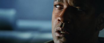 Movie still from “Man on Fire” (2004), directed by Tony Scott – A person's face with a blue background; Extreme Close Up shot, Low angle