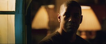 Movie still from “Man on Fire” (2004), directed by Tony Scott – A man's face in a dimly - lit room; Close Up shot, Low angle