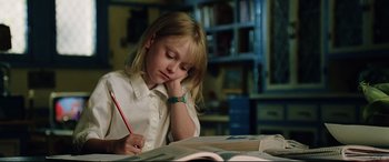 Movie still from “Man on Fire” (2004), directed by Tony Scott – A little girl sitting at a table with a pen and a book; Close Up shot, High angle