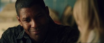 Movie still from “Man on Fire” (2004), directed by Tony Scott – A man smiling for the camera; Close Up shot, Low angle