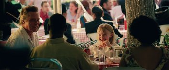 Movie still from “Man on Fire” (2004), directed by Tony Scott – A woman sitting at a table eating food; Medium shot, Over the shoulder angle