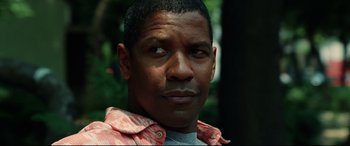 Movie still from “Man on Fire” (2004), directed by Tony Scott – A man's face in the forest; Close Up shot, Low angle