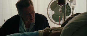 Movie still from “Man on Fire” (2004), directed by Tony Scott – A man is looking at a patient in a hospital bed; Close Up shot, Over the shoulder angle