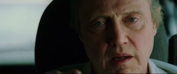 Movie still from “Man on Fire” (2004), directed by Tony Scott – An older man with a blue eye and a white mustache; Close Up shot, Low angle