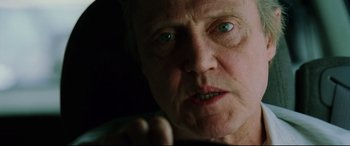 Movie still from “Man on Fire” (2004), directed by Tony Scott – An older man with green eyes looking at the camera; Close Up shot, Low angle