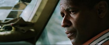 Movie still from “Man on Fire” (2004), directed by Tony Scott – A man's face as he looks out a car window; Close Up shot, Low angle