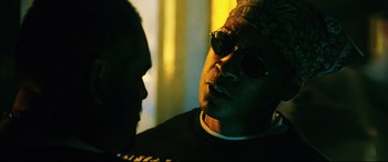 Movie still from “Man on Fire” (2004), directed by Tony Scott – A man wearing sunglasses talking to another man; Close Up shot, Low angle