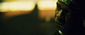 Movie still from “Man on Fire” (2004), directed by Tony Scott – A man's face in the dark; Close Up shot, Low angle