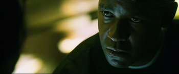 Movie still from “Man on Fire” (2004), directed by Tony Scott – A man's face in the dark; Close Up shot, Low angle