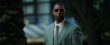 Movie still from “Man on Fire” (2004), directed by Tony Scott – A person wearing a suit and sunglasses; Close Up shot, Low angle