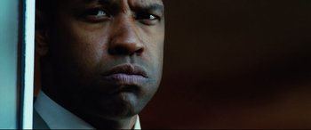 Movie still from “Man on Fire” (2004), directed by Tony Scott – A man's face in a dark room; Close Up shot, Low angle