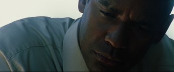 Movie still from “Man on Fire” (2004), directed by Tony Scott – A man's face in a white shirt; Extreme Close Up shot, Low angle