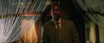 Movie still from “Man on Fire” (2004), directed by Tony Scott – A man in a suit and tie standing in a room; Close Up shot, Low angle