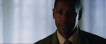 Movie still from “Man on Fire” (2004), directed by Tony Scott – A person wearing a suit and tie; Close Up shot, Over the shoulder angle