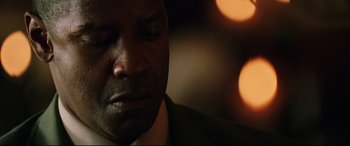 Movie still from “Man on Fire” (2004), directed by Tony Scott – A man in a suit looking down; Close Up shot, Low angle