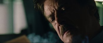 Movie still from “Man on Fire” (2004), directed by Tony Scott – A man's face with smoke coming out of his mouth; Close Up shot, Low angle
