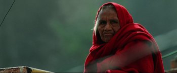 Movie still from “Man on Fire” (2004), directed by Tony Scott – An old woman wearing a red shawl and looking at the camera; Close Up shot, Low angle