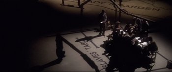 A group of people sitting in a room with shadows on the floor