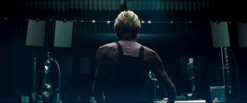 A man with blond hair is standing in a gym