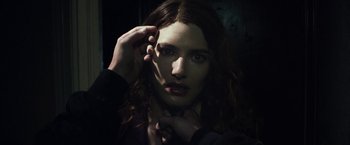 Movie still from “Maniac” (2012), directed by Franck Khalfoun – A woman with long dark brown hair is holding her hand up to her face; Close Up shot, Over the shoulder angle