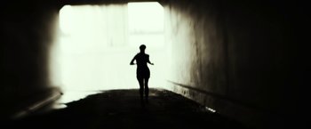 Movie still from “Maniac” (2012), directed by Franck Khalfoun – A woman is running in a tunnel with a light coming through the window; Close Up shot, Low angle