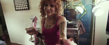Movie still from “Maniac” (2012), directed by Franck Khalfoun – A woman in a pink shirt with tattoos on her arms; Close Up shot, Over the shoulder angle