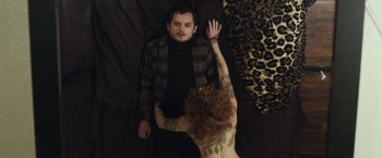 Movie still from “Maniac” (2012), directed by Franck Khalfoun – A man and a tattooed woman on a bed; Medium shot, Overhead angle