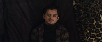 Movie still from “Maniac” (2012), directed by Franck Khalfoun – A man with a beard is laying on a blanket; Close Up shot, High angle