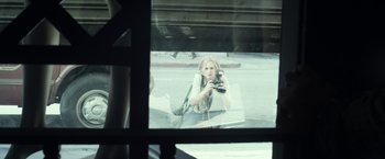 Movie still from “Maniac” (2012), directed by Franck Khalfoun – A woman taking a picture through a window; Medium shot, Over the shoulder angle