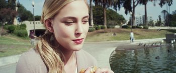 Movie still from “Maniac” (2012), directed by Franck Khalfoun – A beautiful young lady holding a hot dog in her hand; Close Up shot, Over the shoulder angle