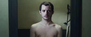 Movie still from “Maniac” (2012), directed by Franck Khalfoun – A young man with a beard is posing for the camera; Close Up shot, High angle