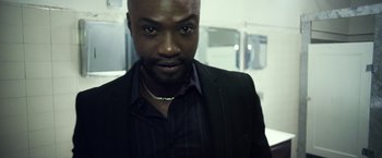 Movie still from “Maniac” (2012), directed by Franck Khalfoun – A person wearing a suit and tie; Close Up shot, Low angle