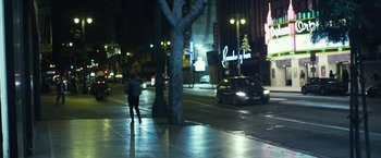 Movie still from “Maniac” (2012), directed by Franck Khalfoun – A person walking on the sidewalk at night near a tree; Extreme Wide shot, High angle