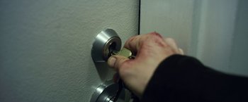Movie still from “Maniac” (2012), directed by Franck Khalfoun – A hand is holding a key to a door knob; Extreme Close Up shot, High angle