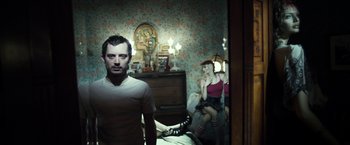 Movie still from “Maniac” (2012), directed by Franck Khalfoun – A man and a woman sitting on a bed in front of a mirror; Medium shot, High angle