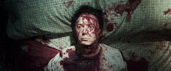 Movie still from “Maniac” (2012), directed by Franck Khalfoun – A man with blood all over his face and chest; Close Up shot, Overhead angle