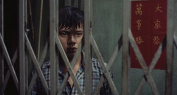 A man standing in front of a metal gate