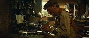 Movie still from “Manon of the Spring” (1986), directed by Claude Berri – A man working in a workshop on a piece of metal; Close Up shot, Low angle
