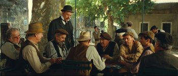 Movie still from “Manon of the Spring” (1986), directed by Claude Berri – A group of men sitting at a table playing cards; Wide shot, High angle