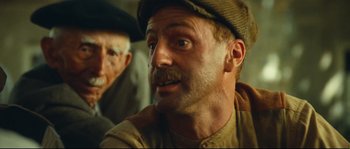 Movie still from “Manon of the Spring” (1986), directed by Claude Berri – A man with a beard and a hat is looking at the camera; Close Up shot, Low angle