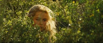 Movie still from “Manon of the Spring” (1986), directed by Claude Berri – A woman with long blonde hair is in the bushes; Close Up shot, Over the shoulder angle