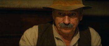 Movie still from “Manon of the Spring” (1986), directed by Claude Berri – An old man with a mustache wearing a hat; Close Up shot, Over the shoulder angle