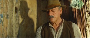 Movie still from “Manon of the Spring” (1986), directed by Claude Berri – An older man wearing a cowboy hat and vest; Close Up shot, Low angle