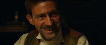 Movie still from “Manon of the Spring” (1986), directed by Claude Berri – A person with a mustache smiling; Close Up shot, Low angle