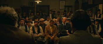 Movie still from “Manon of the Spring” (1986), directed by Claude Berri – A group of people sitting in a room; Wide shot, High angle