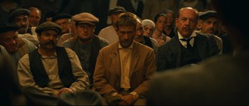 Movie still from “Manon of the Spring” (1986), directed by Claude Berri – A group of people sitting in a room; Medium shot, High angle