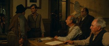 Movie still from “Manon of the Spring” (1986), directed by Claude Berri – A group of people sitting at a table; Medium shot, Over the shoulder angle